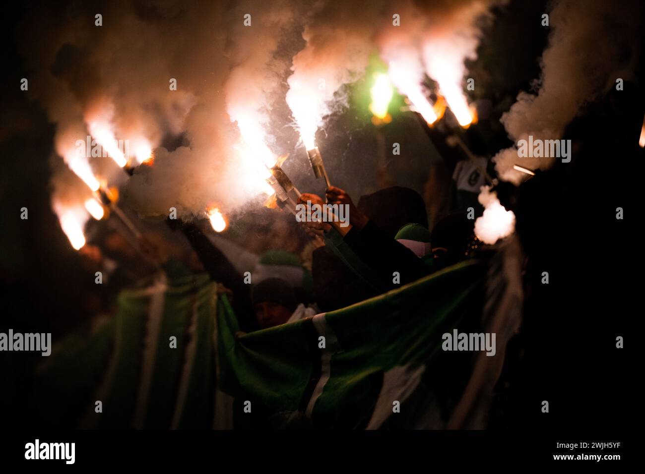 Budapest, Hungary. 15th Feb, 2024. Maccabi's fans are lighting fireworks during a soccer game between Israeli club Maccabi Haifa and Belgian KAA Gent, Friday 15 December 2023 in Budapest, Hungary, the first leg of the knockout round play-offs of the UEFA Conference League competition. BELGA PHOTO JASPER JACOBS Credit: Belga News Agency/Alamy Live News Stock Photo