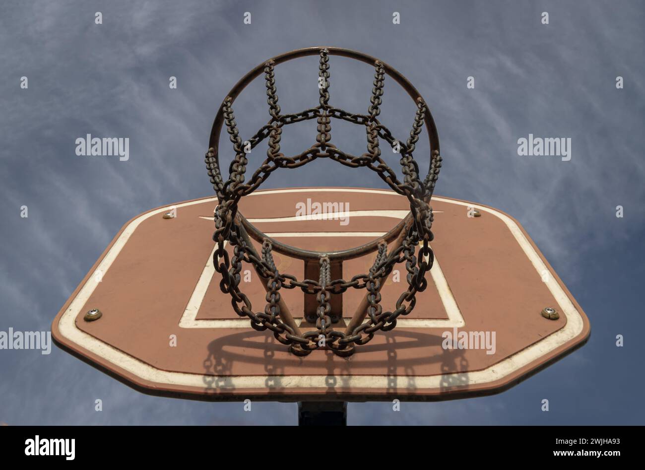 Edinburgh, Scotland, Jan 19, 2024 - View of Basketball backboard with the hoop metal ring and steel chain net against blue sky background seen from be Stock Photo