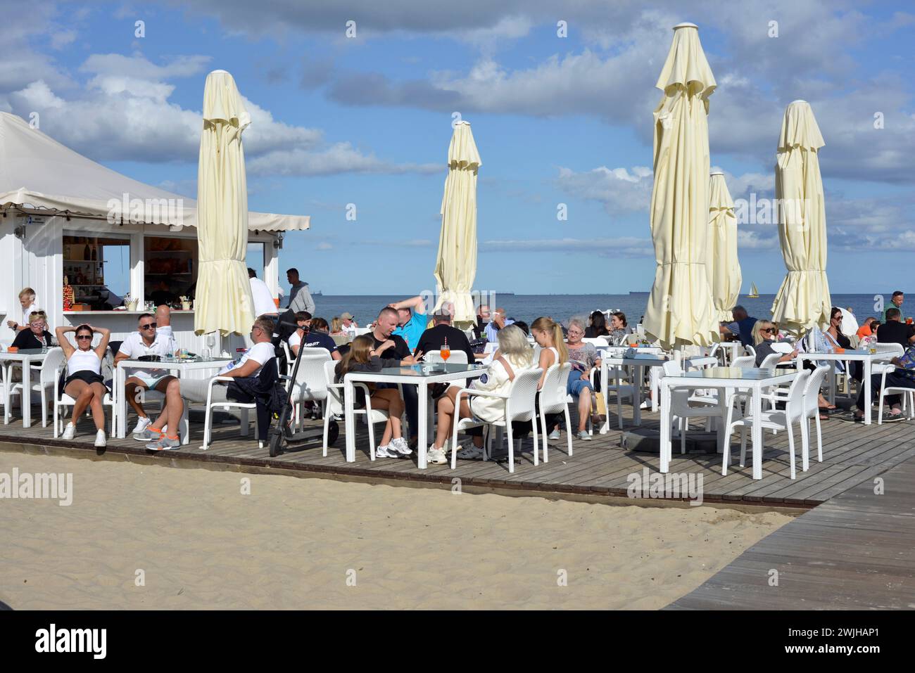 People alfresco at a beach bar on the Baltic Sea in the resort town of Sopot, Poland, Europe, EU Stock Photo