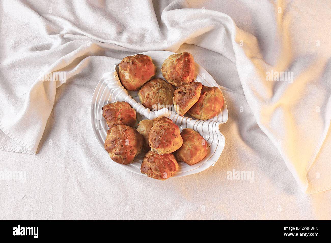 A white plate showcasing a delectable assortment of four freshly baked culinary delights, elegantly presented on a table Stock Photo