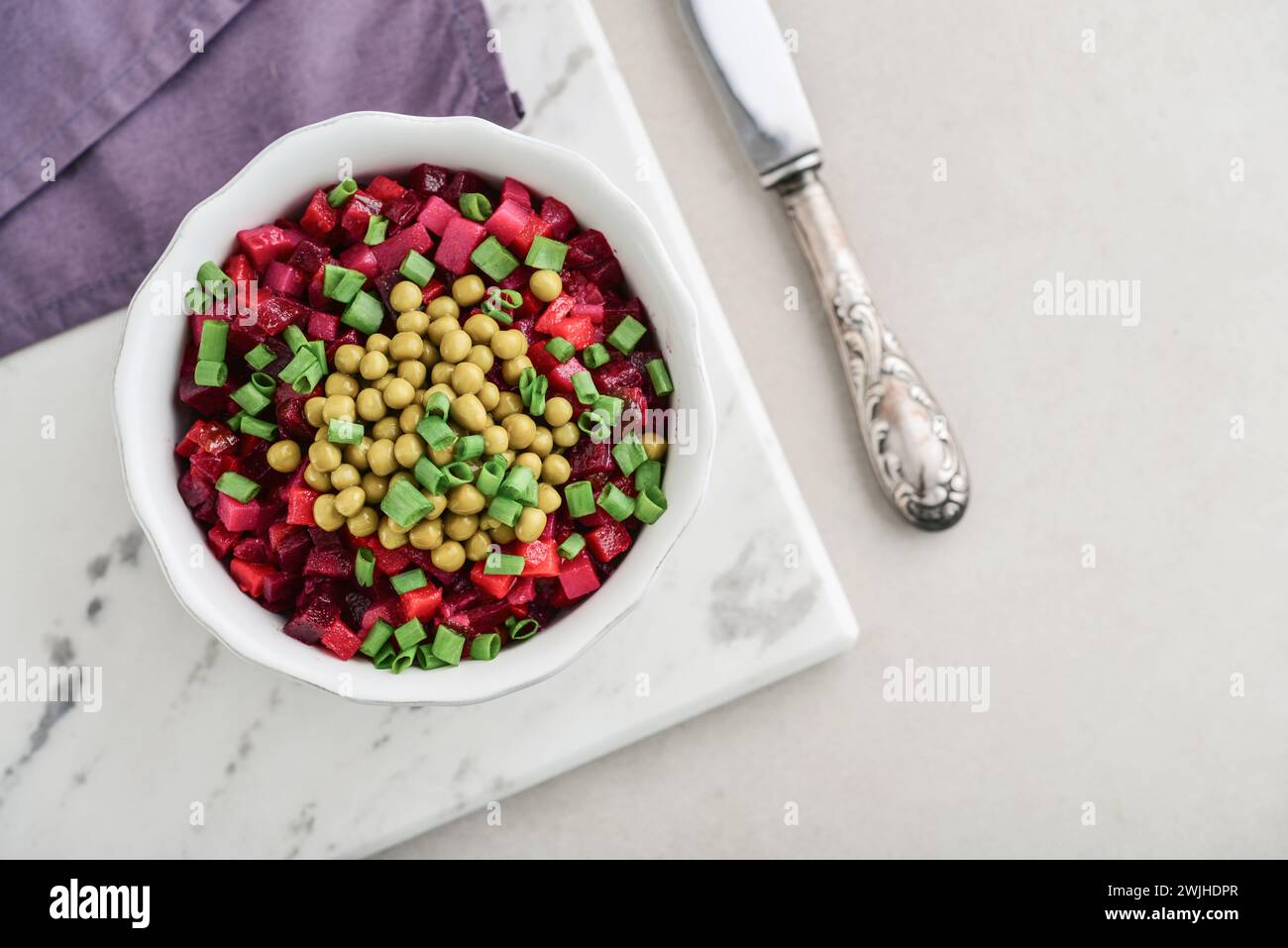 Vinegret - traditional Russian vegetable salad in bowl on light background, top view Stock Photo