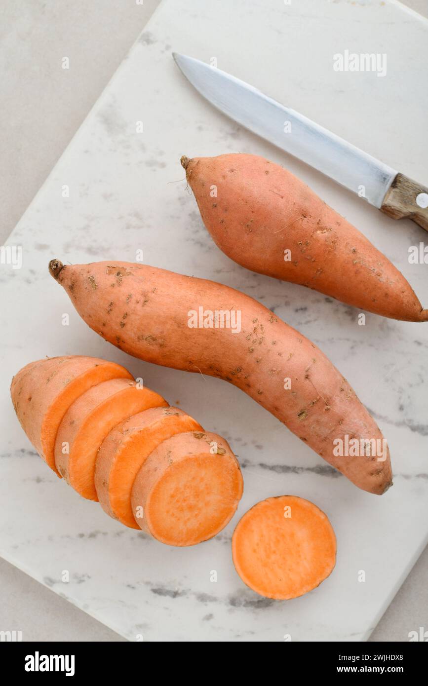 Set of fresh whole and sliced sweet potatoes  on light background. Top view Stock Photo