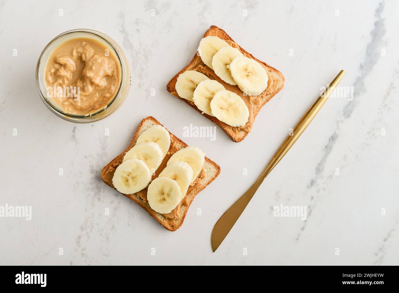 Peanut butter sandwich with fresh banana slices on marble table, top view Stock Photo