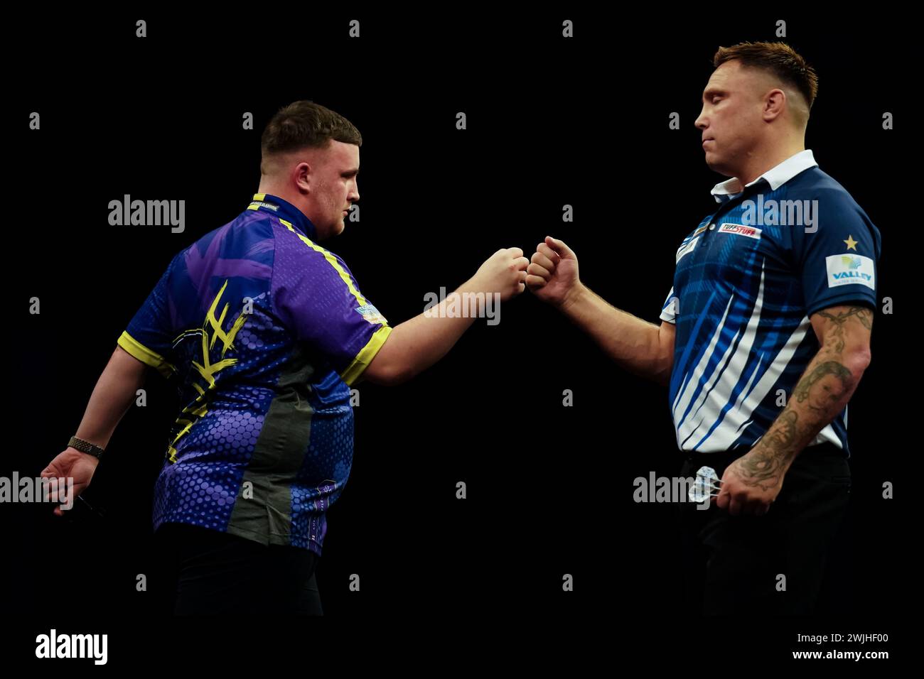 Gerwyn Price and Luke Littler fist bump during night three of the 2024