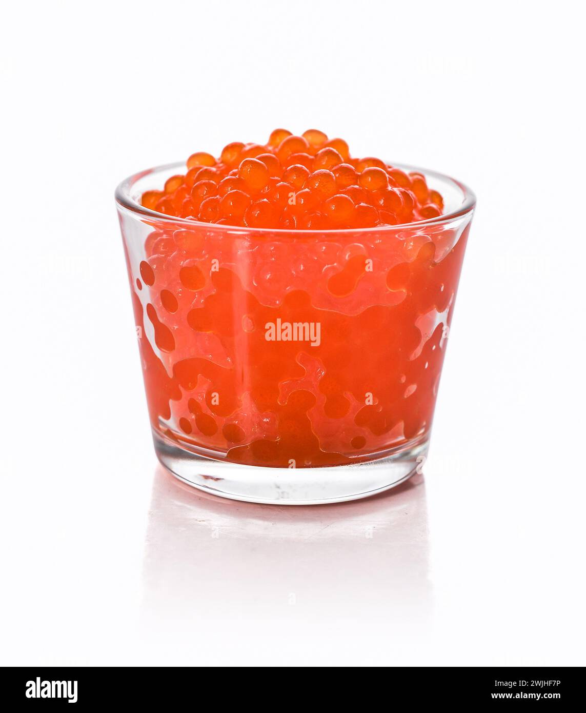 Glass of red trout caviar isolated on a white background Stock Photo