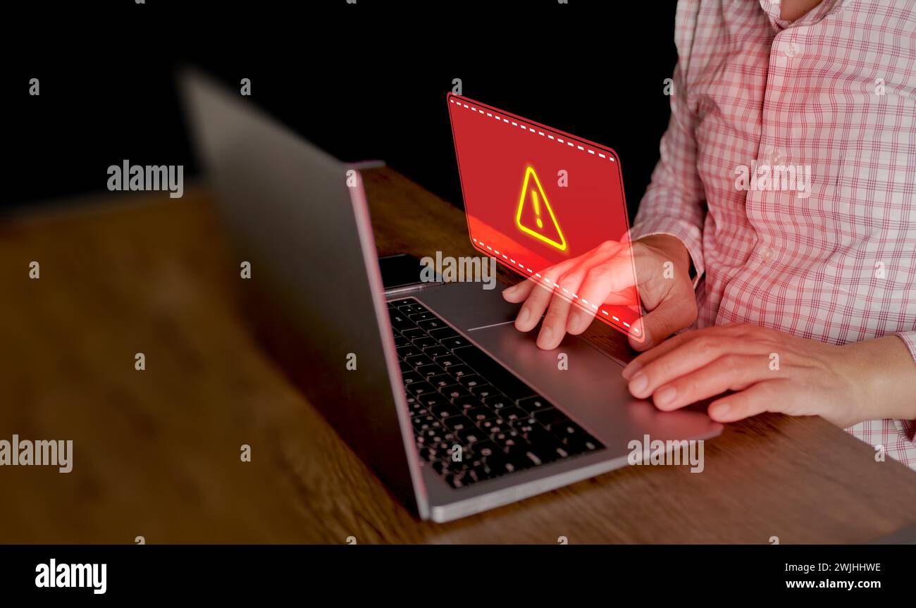 Cyber security concept. Red system hacked warning sign alerts on a computer notebook screen. Cybercrime, virus, online hacking, cyber attack, maliciou Stock Photo