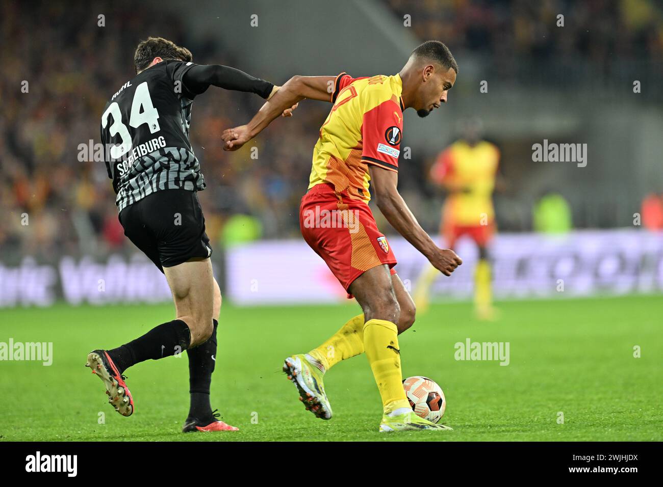 Lens, France. 15th Feb, 2024. Andy Diouf (18) of RC Lens fighting for the ball with Merlin Röhl (34) of Freiburg during the Uefa Europa League play-off -first leg game in the 2023-2024 season between Racing Club de Lens and SC Freiburg on February 15, 2024 in Lens, France. (Photo by David Catry/Isosport) Credit: sportpix/Alamy Live News Stock Photo