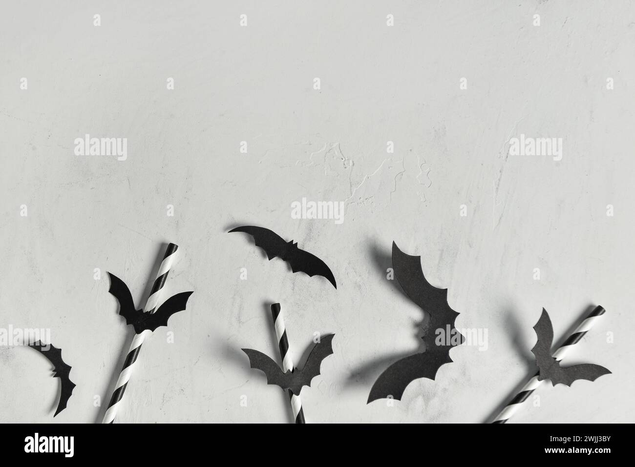 Drinking straws and paper bats for Halloween celebration on light ...