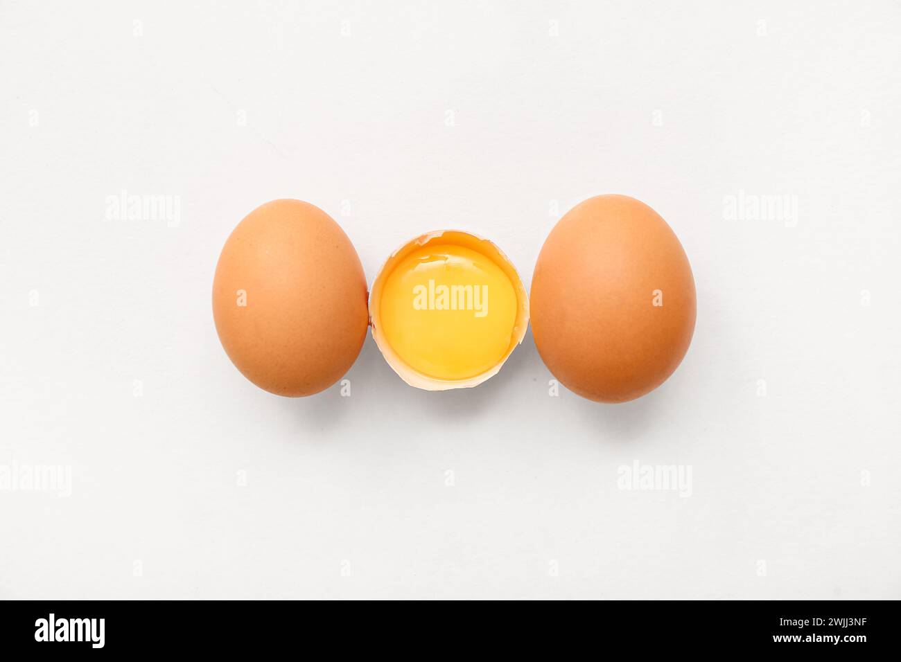 Cracked and whole chicken eggs on white background Stock Photo - Alamy