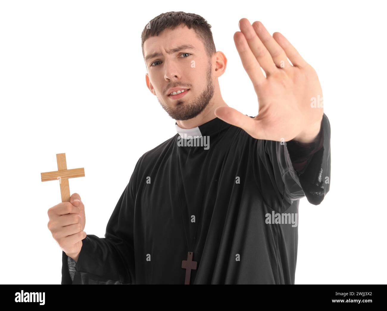 Young priest with cross showing stop gesture on white background ...