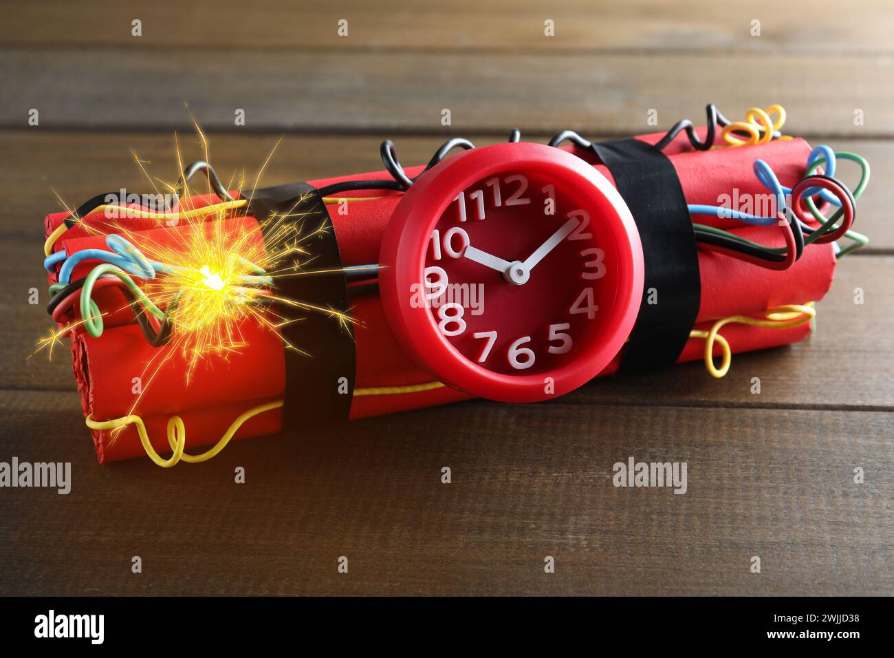 Dynamite time bomb with burning wires on wooden table Stock Photo