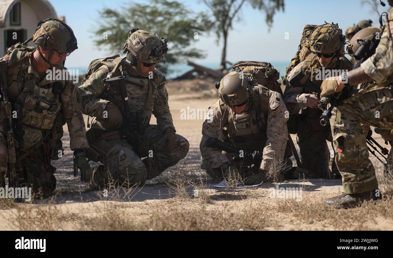 240206-M-IU565-1149 FAILAKA ISLAND, Kuwait (Feb. 6, 2024) A Marine assigned to Fleet Anti-Terrorism Security Team Central Command passes information to U.S. and British service members while participating in the final evolution of exercise Eager Defender 24 on Failaka Island, Kuwait, Feb. 6. Eager Defender 24 is the capstone in a series of bilateral exercises between Kuwait and U.S. naval forces, focused on enhancing mutual capabilities and interoperability in maritime security operations. (U.S. Marine Corps photo) Stock Photo