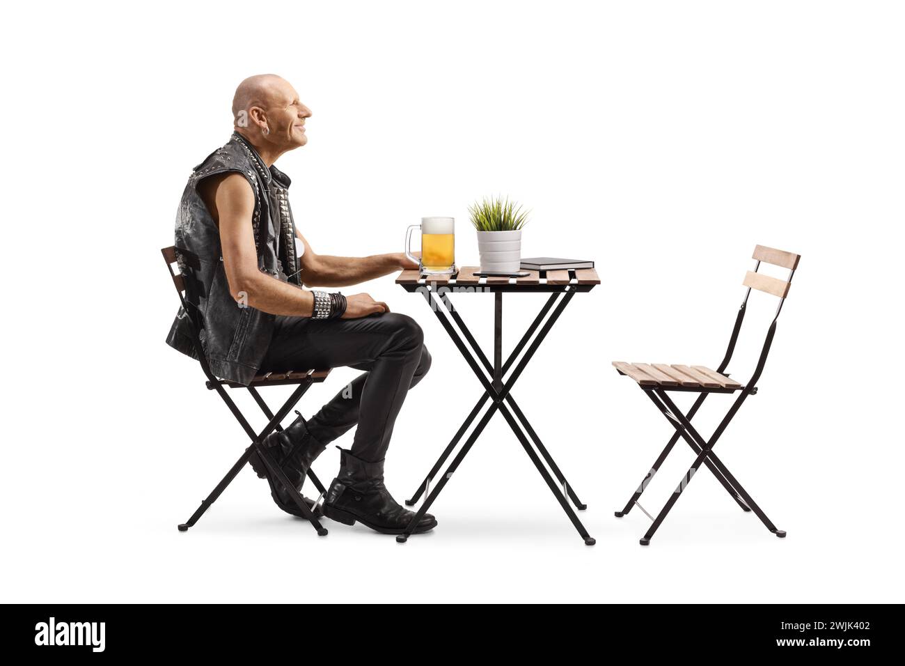 Punk with a pint of beer at a cafe table isolated on white background ...