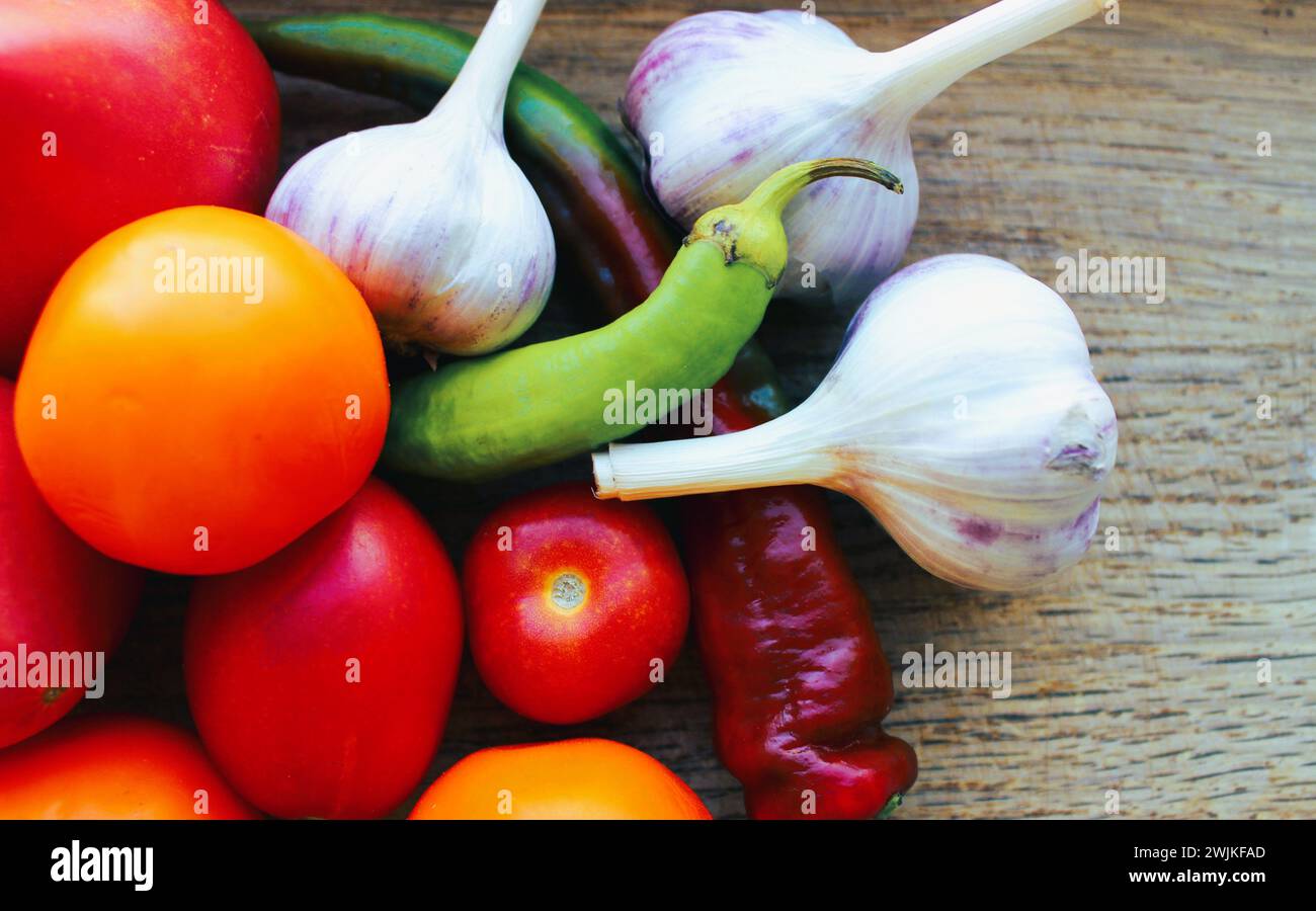 Seasonal vegetables collected from the garden lie on a wooden surface Stock Photo