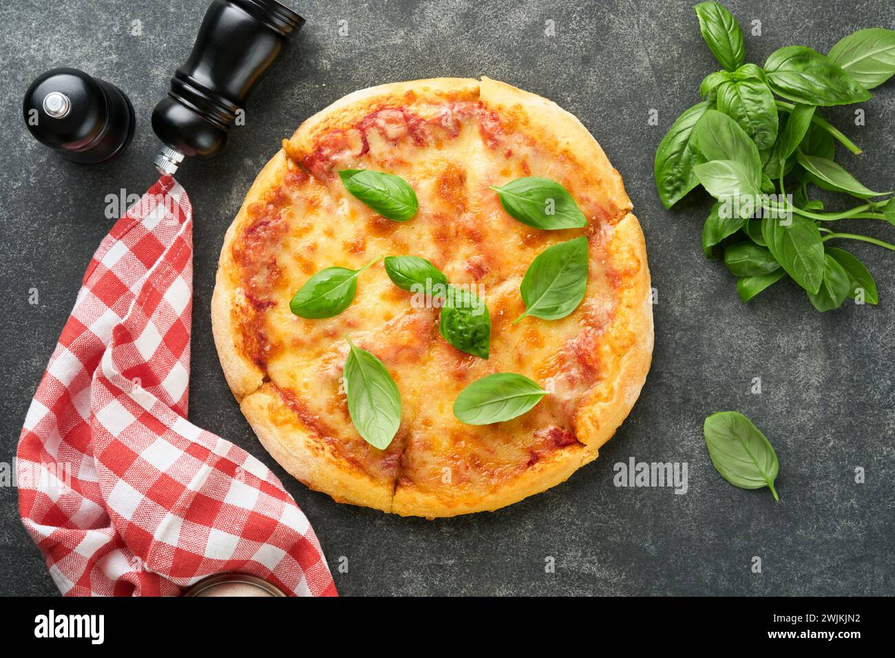 Margarita pizza. Traditional neapolitan margarita pizza and cooking ingredients tomatoes basil on old concrete texture background table. Italian Tradi Stock Photo