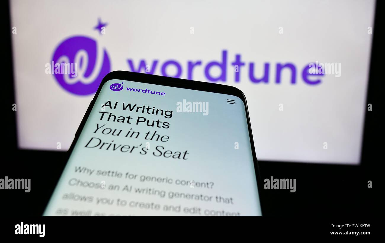 Mobile phone with web page of artificial intelligence companion Wordtune (AI21 Labs) in front of logo. Focus on top-left of phone display. Stock Photo