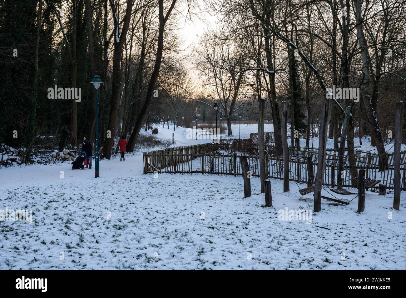 Jette, Brussels, Belgium, 21 January 2024 - Families with children walking in the snow in a city park Stock Photo