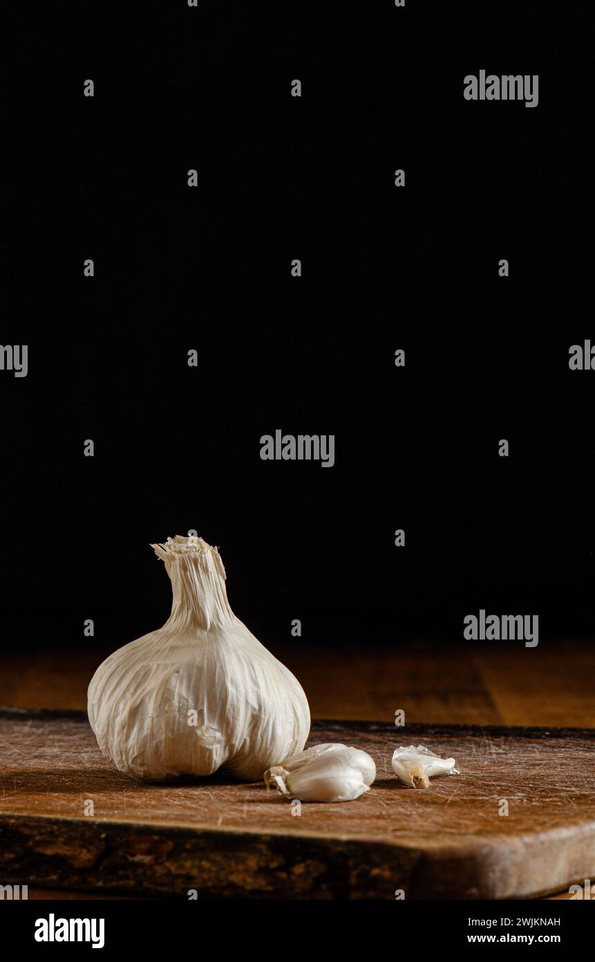 Garlic cloves on wooden surface and dark background Stock Photo - Alamy
