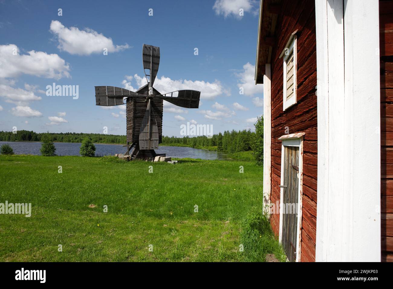 An old windmill by a lake Stock Photo