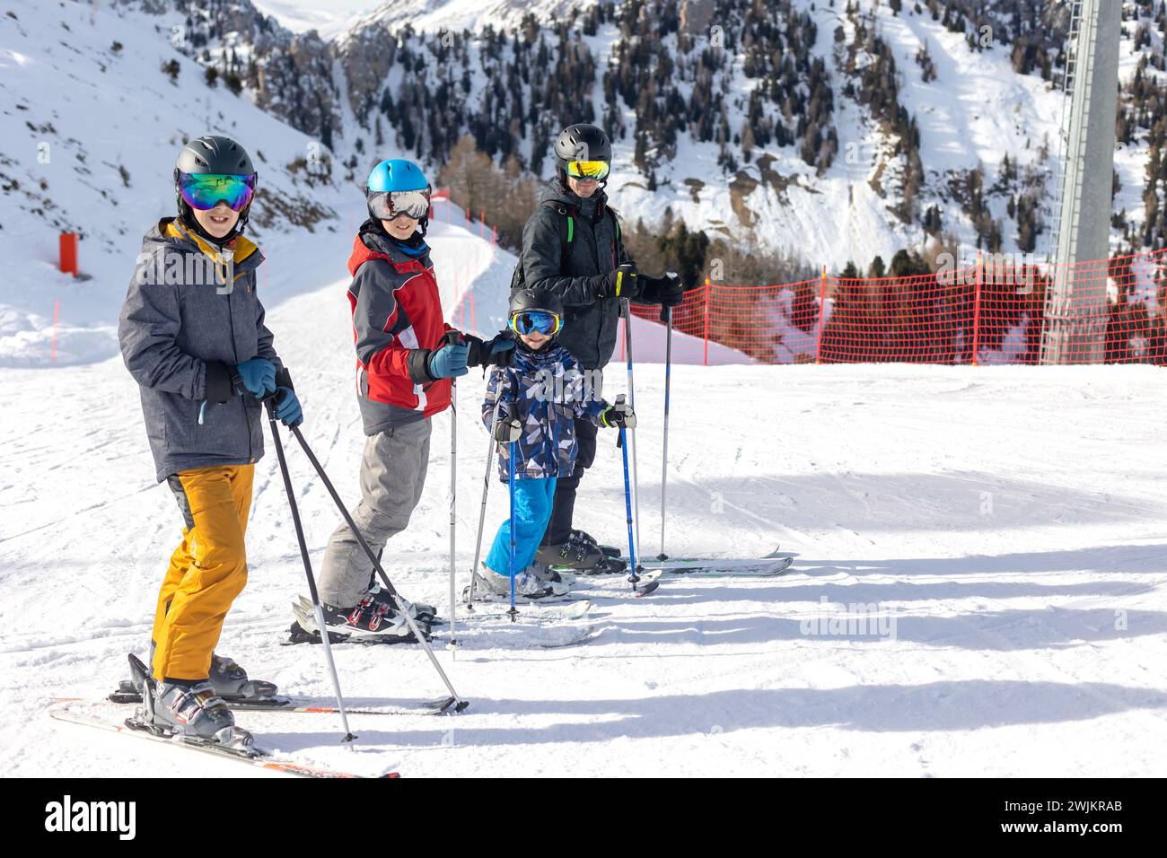 Children and adults, happy family in winter clothing at ski vacation, skiing, wintertime Stock Photo