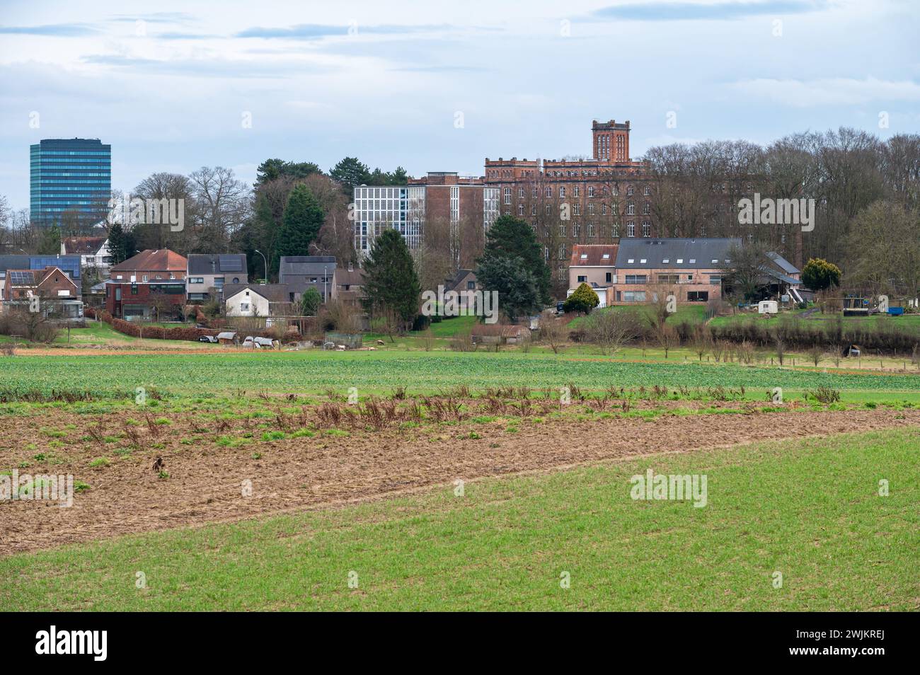Leuven, Flemish Brabant, Belgium, February 10, 2024 - Green meadows with the technological university building in the background Stock Photo