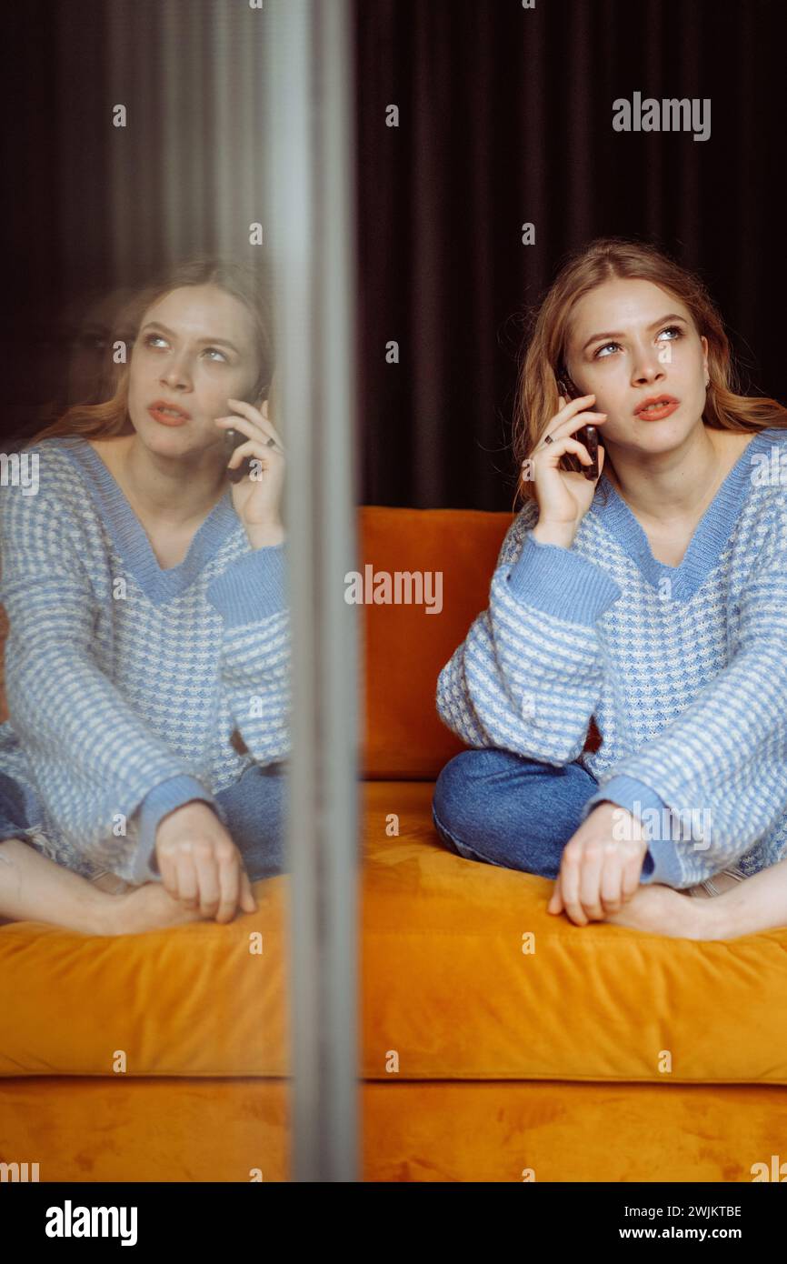 Young woman talking on the phone, calling loved ones Stock Photo