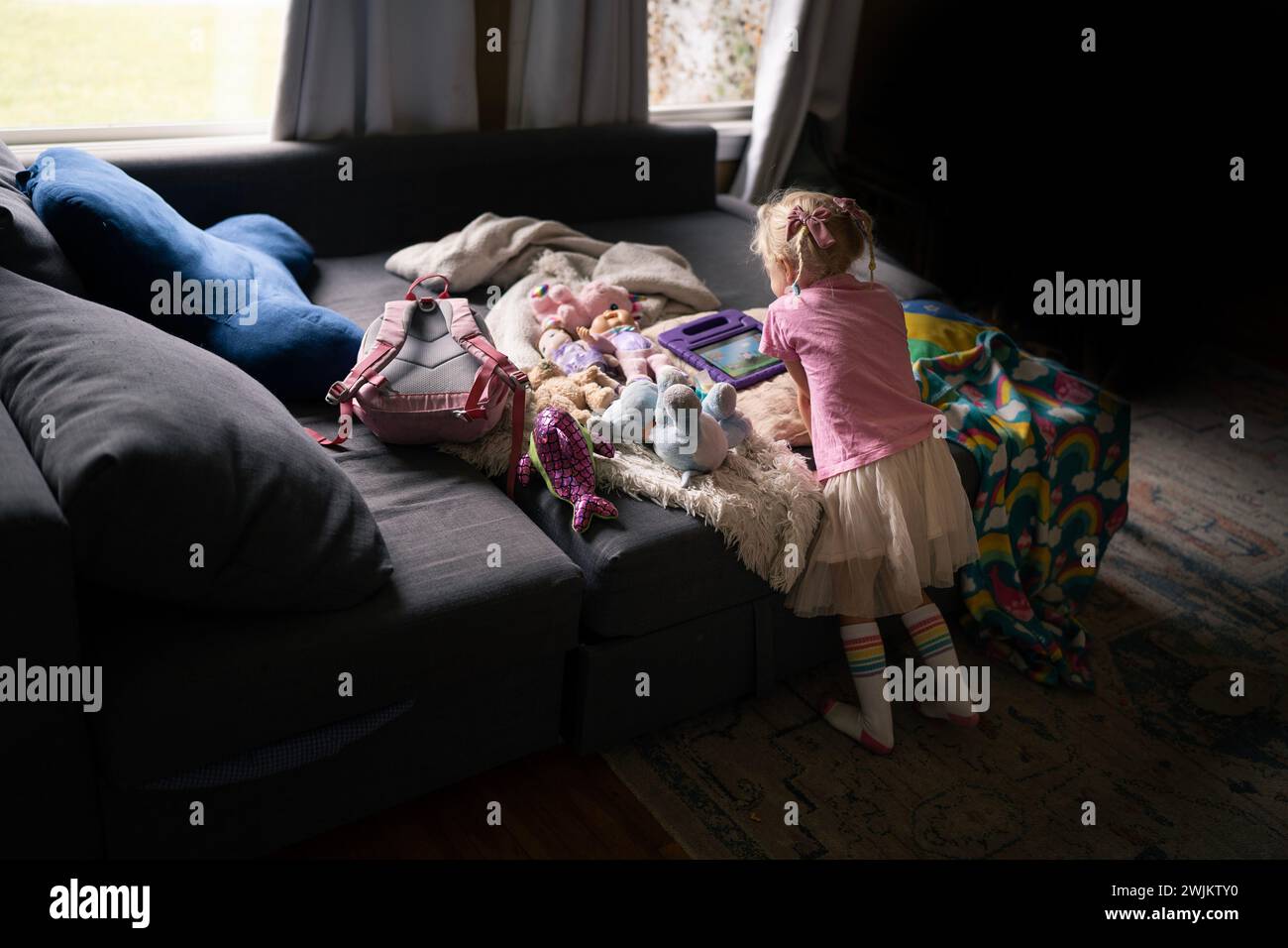 Little Girl Watches Her iPad with Stuffed Friends Stock Photo