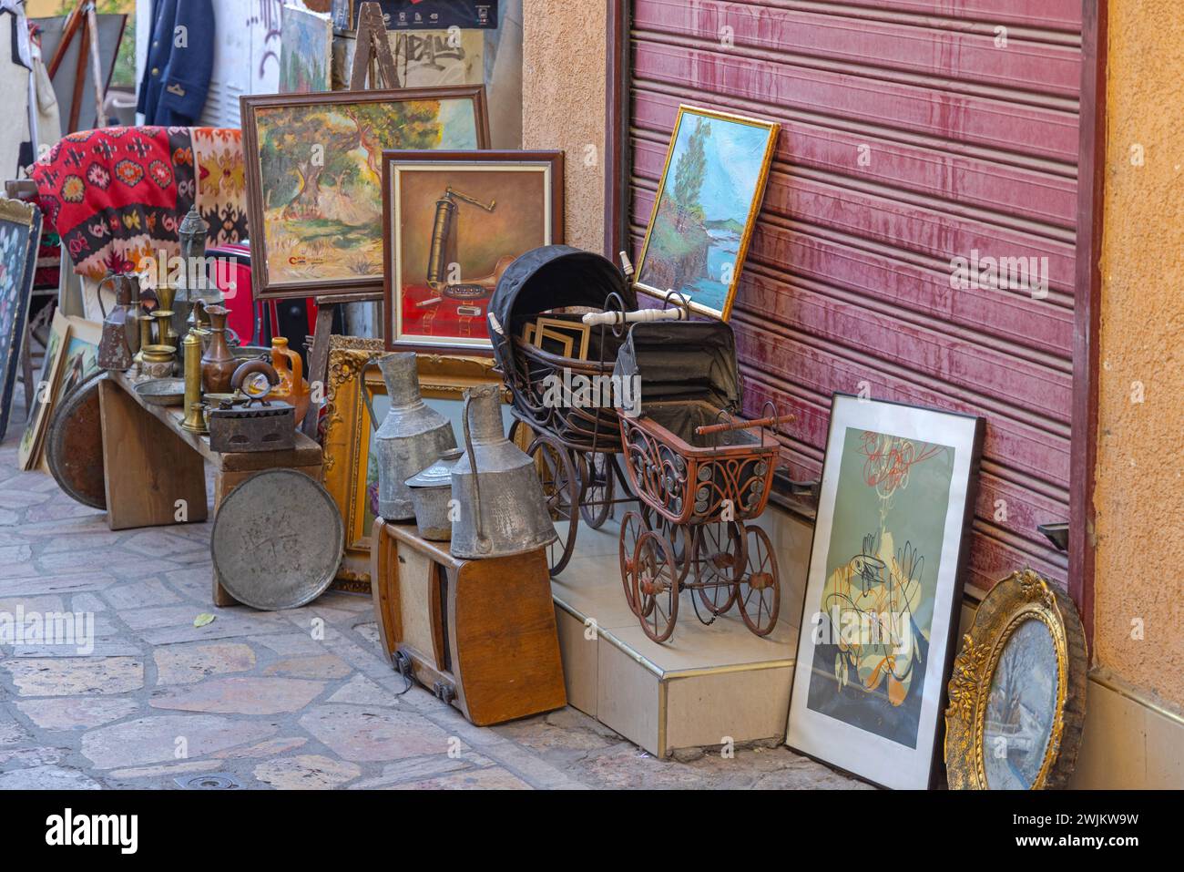Skopje, North Macedonia - October 23, 2023: Art Paintings Toys Rugs Display in Front of Antique Shop at Street in Old Town. Stock Photo