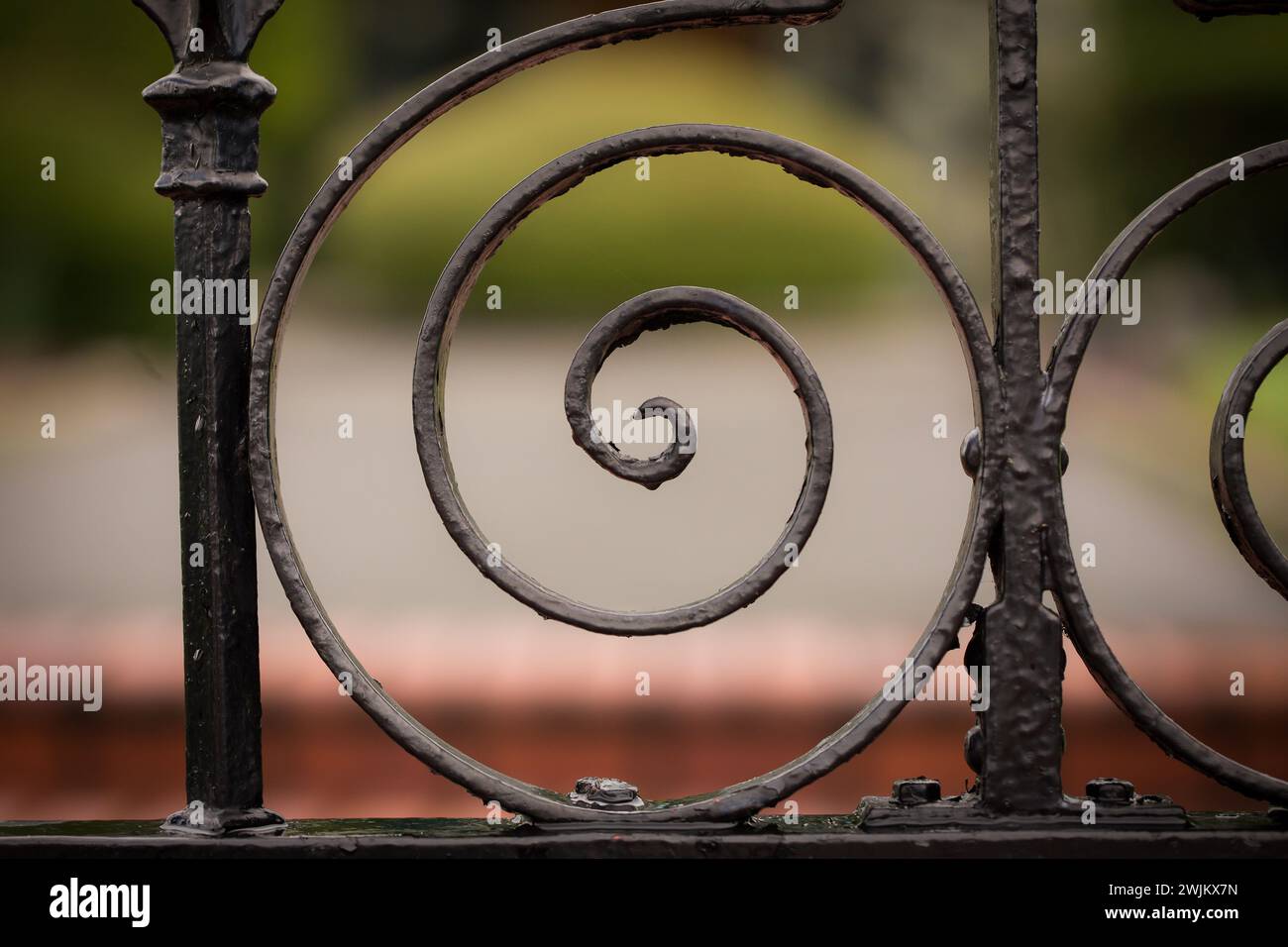 Curly black wrought iron fence up close Stock Photo