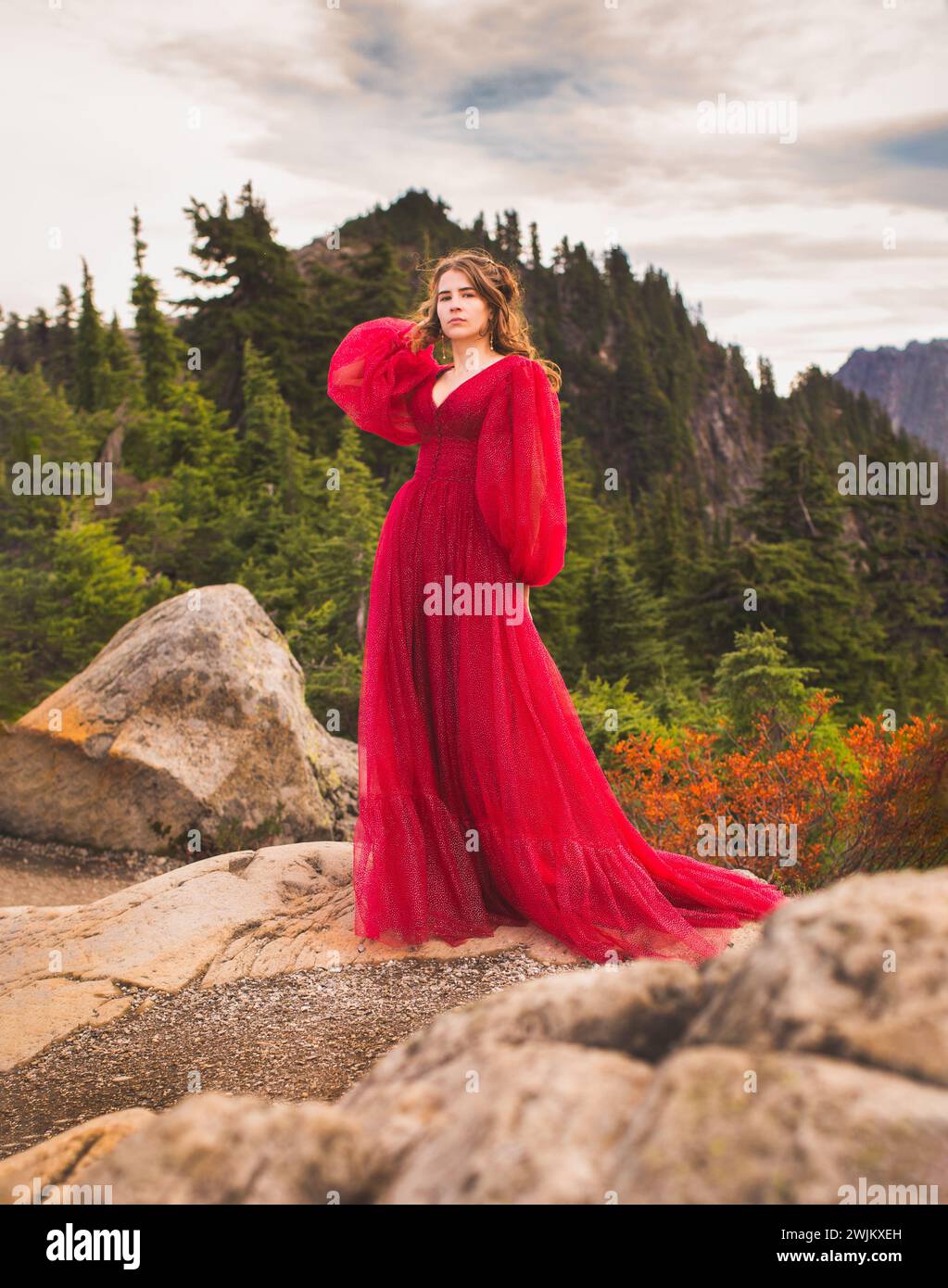 Confident Young Woman in Red Dress on Mountain Stock Photo - Alamy