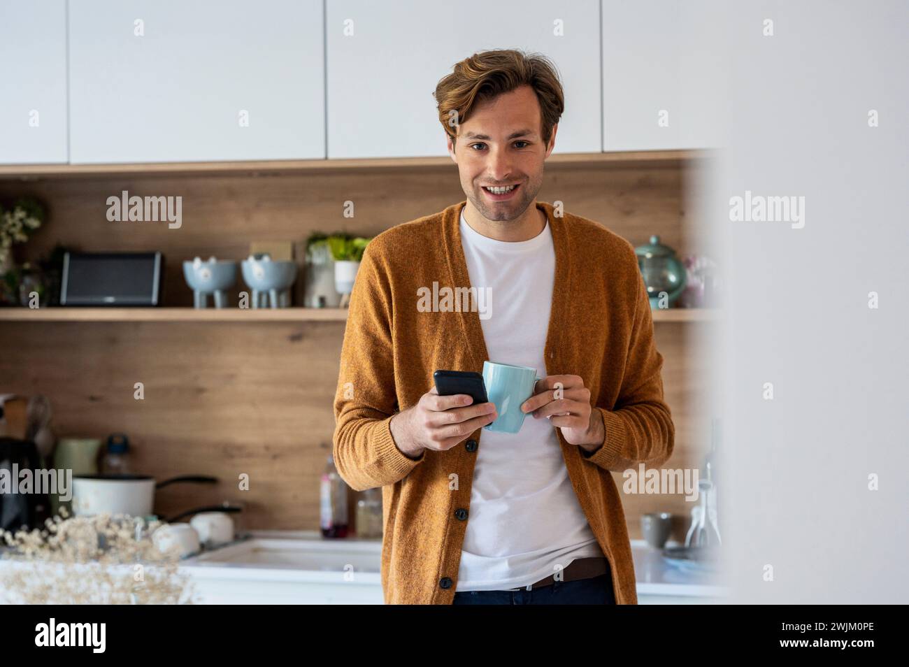 Adult man looking at the camera while using smart phone Stock Photo