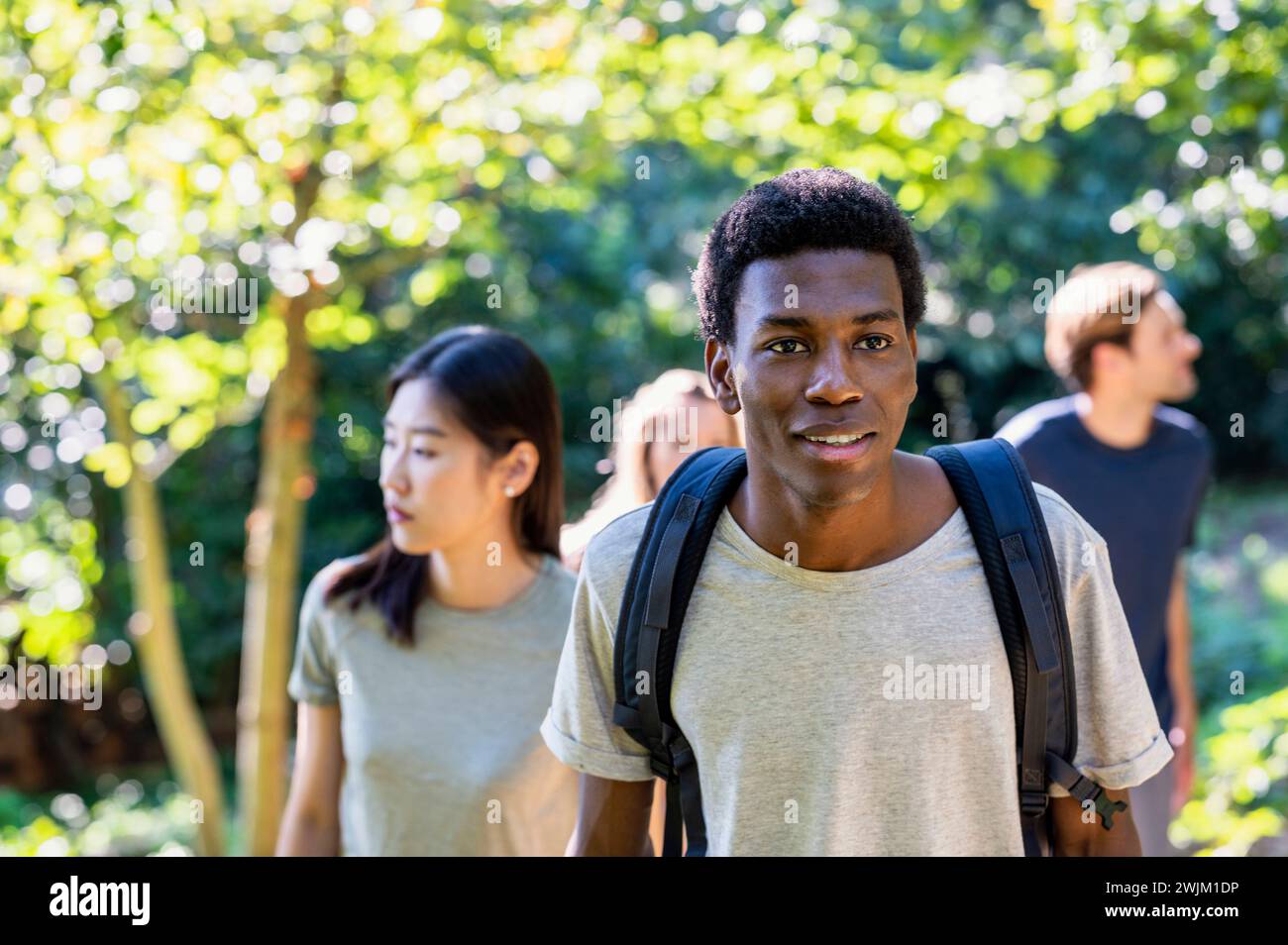 Young adult man wearing backpack during hiking with friends Stock Photo
