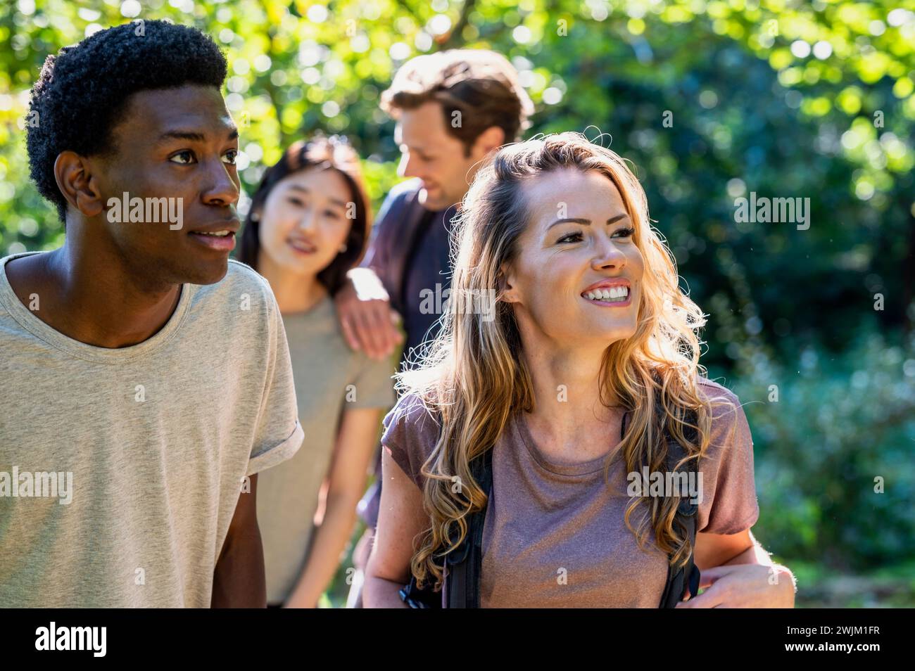 Group of friends hiking in the woods during daytime Stock Photo