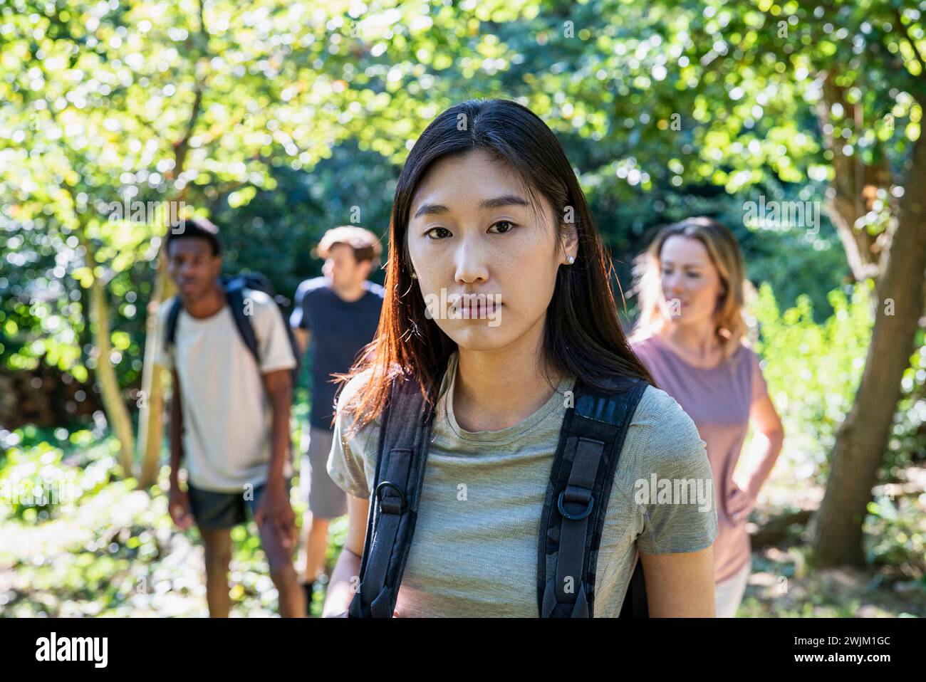 Young adult woman looking at the camera while hiking with friends Stock Photo
