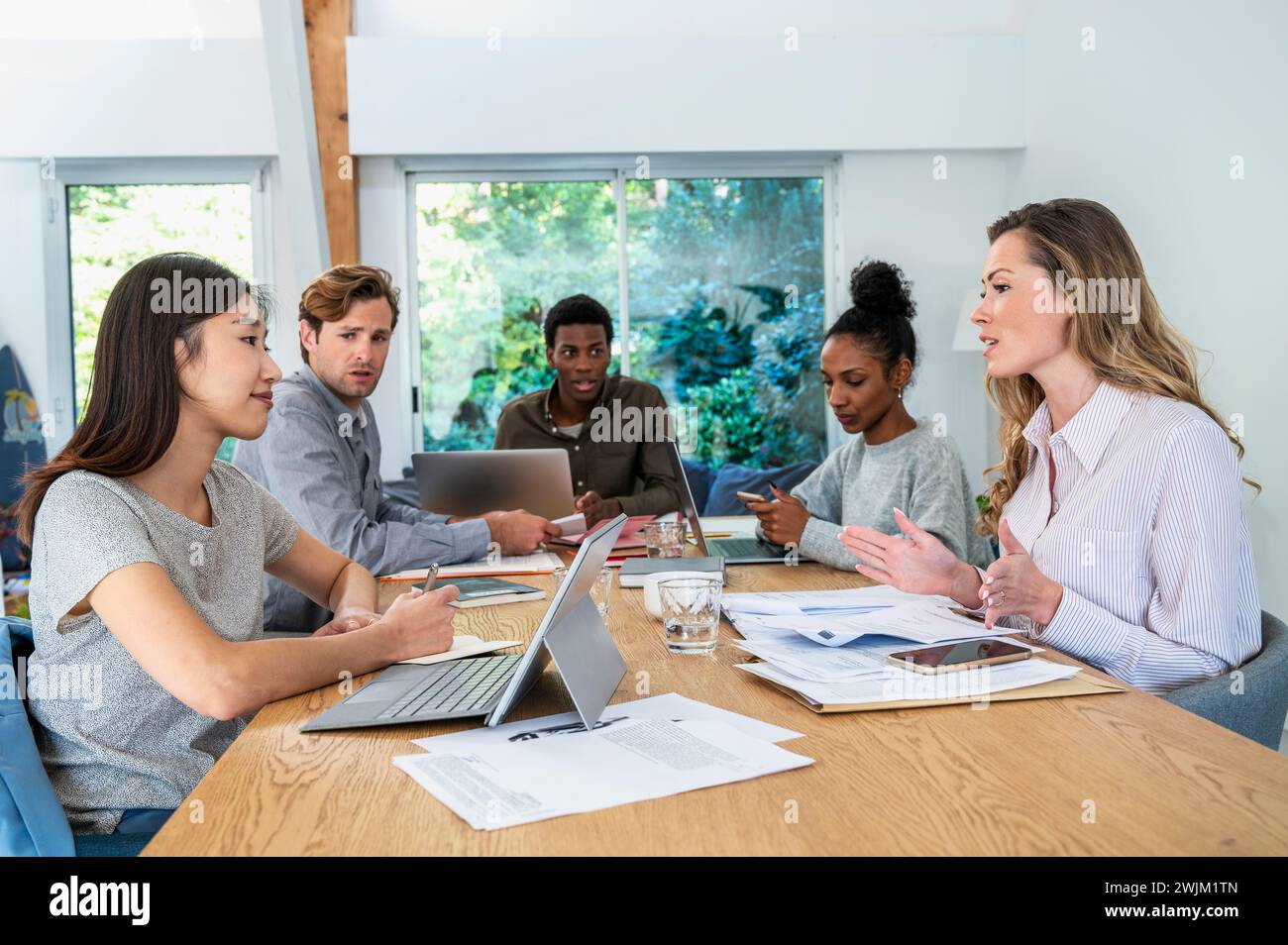 Business people discussing project while gathered at office Stock Photo
