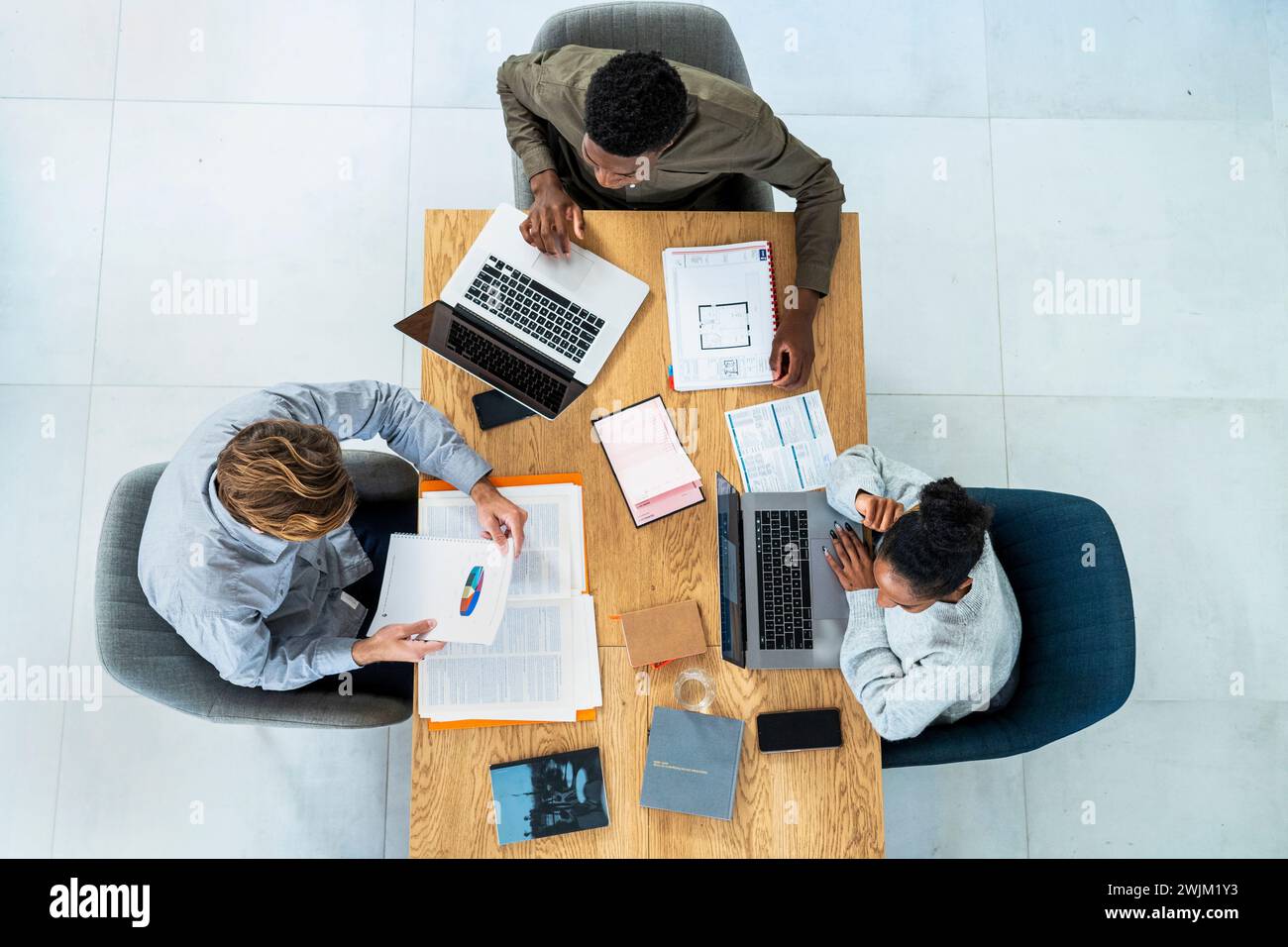 Financial team sitting at desk while working on project Stock Photo