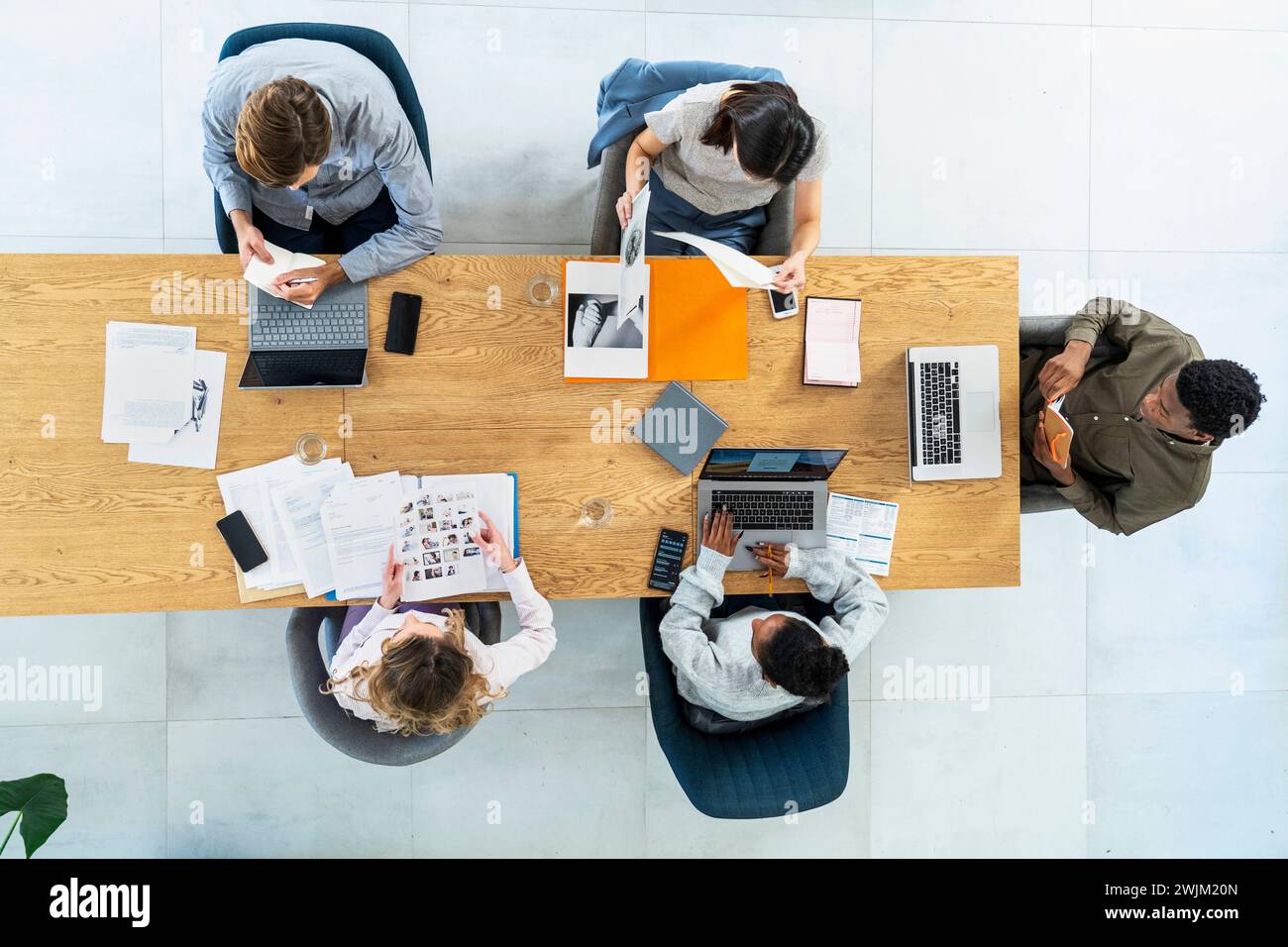 Advertising agency workers sitting at table using laptop Stock Photo