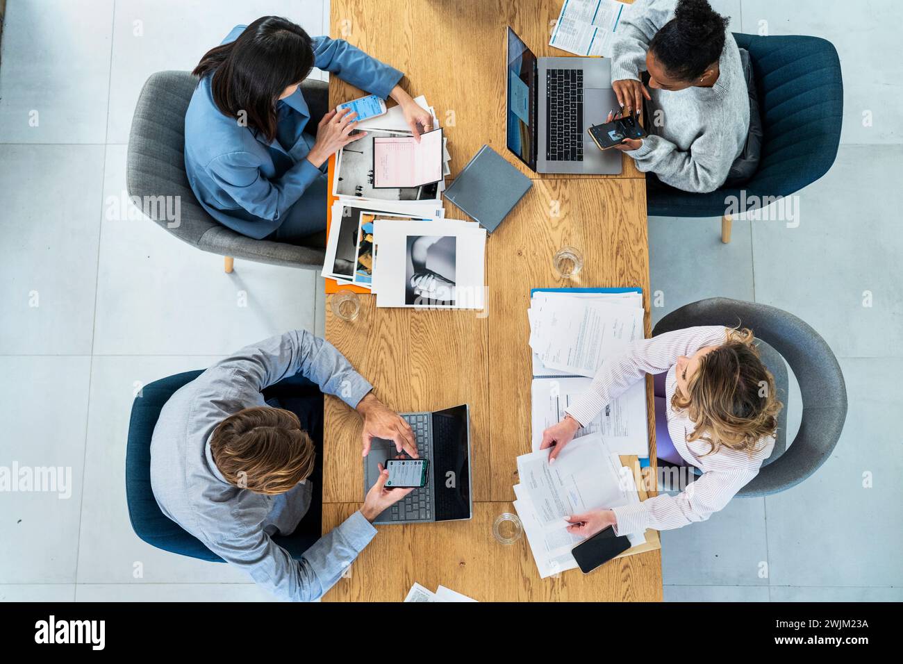 Advertising agency workers sitting at table using laptop Stock Photo