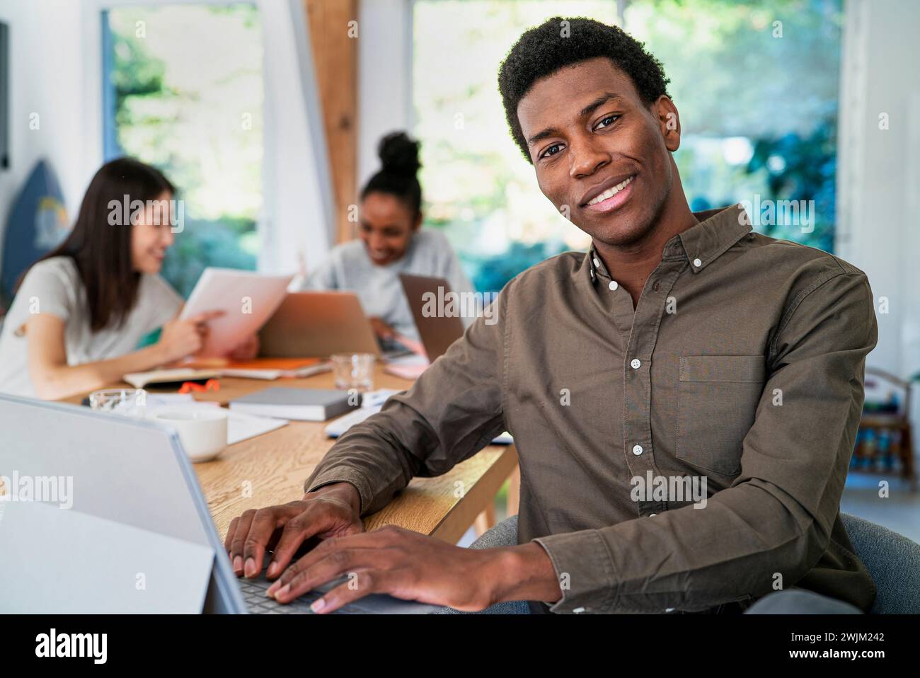 Head manager working at desk while using digital tablet looking at the camera Stock Photo