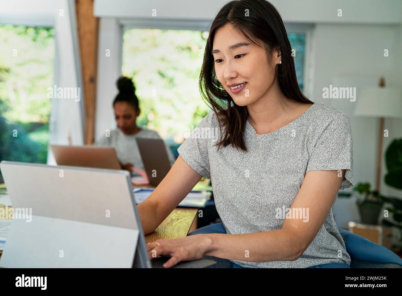 Female community manager using digital tablet while sitting at desk Stock Photo