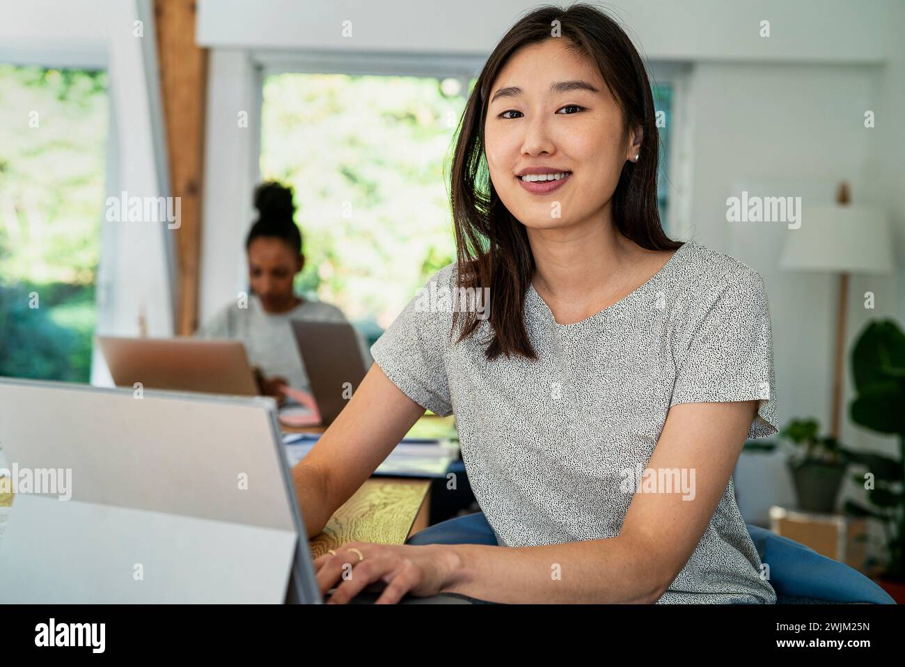 Female community manager using digital tablet while sitting at desk Stock Photo