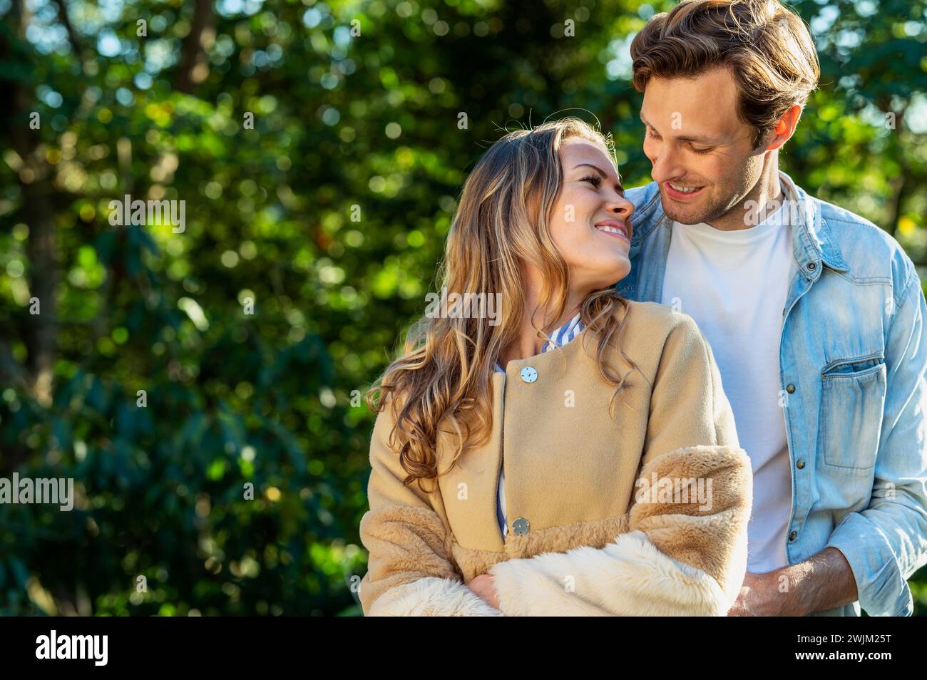 Adult couple looking at each other closely while standing outdoors Stock Photo