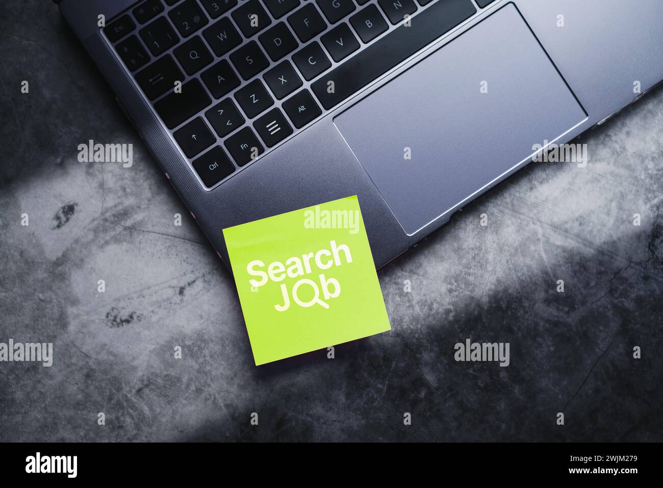 Laptop top view photo with green post it for job search concept. Find your career. Work search online with empty space for text. Stock Photo