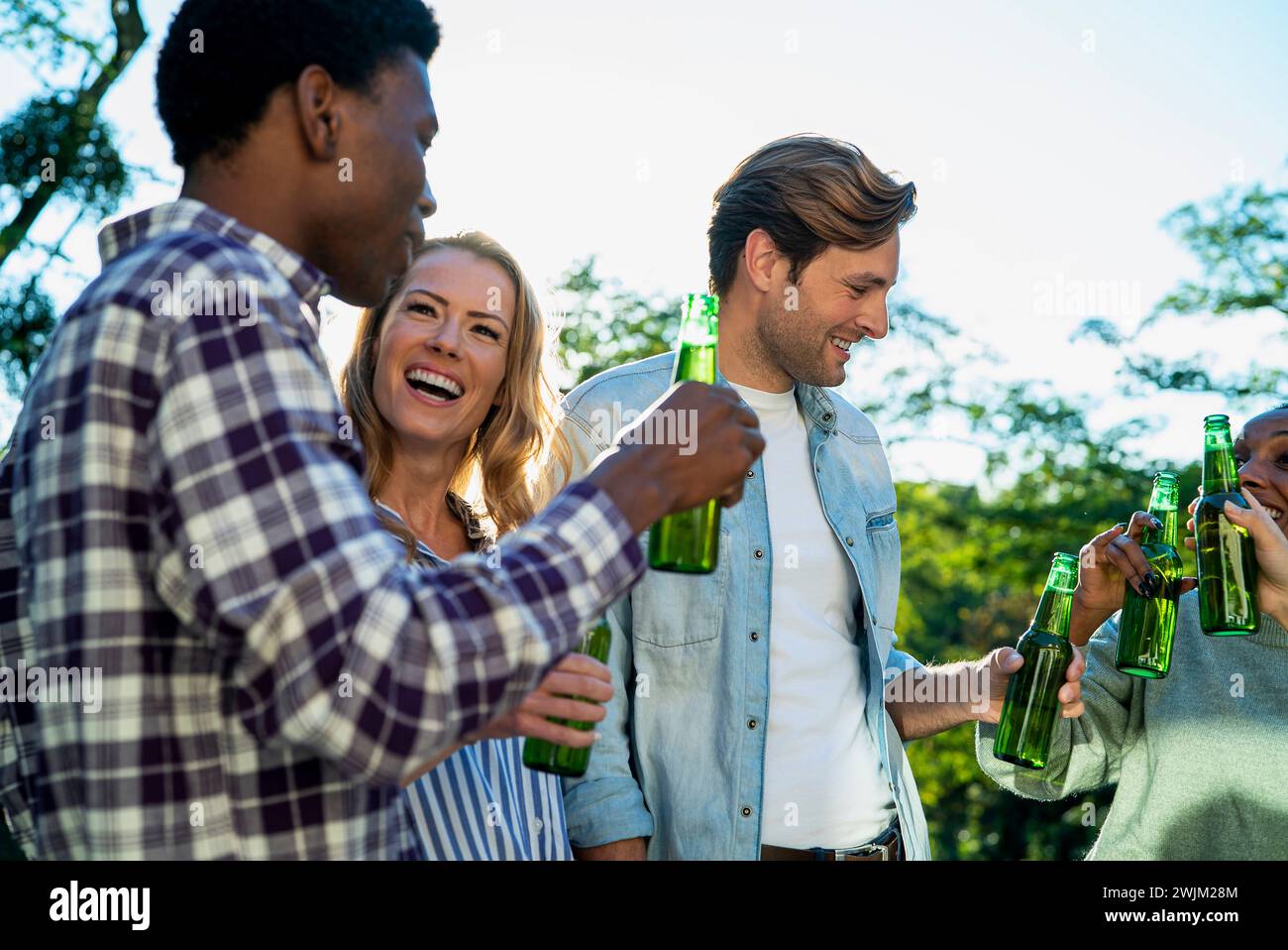 Group of friends hanging on rooftop drinking beer during sunset Stock Photo