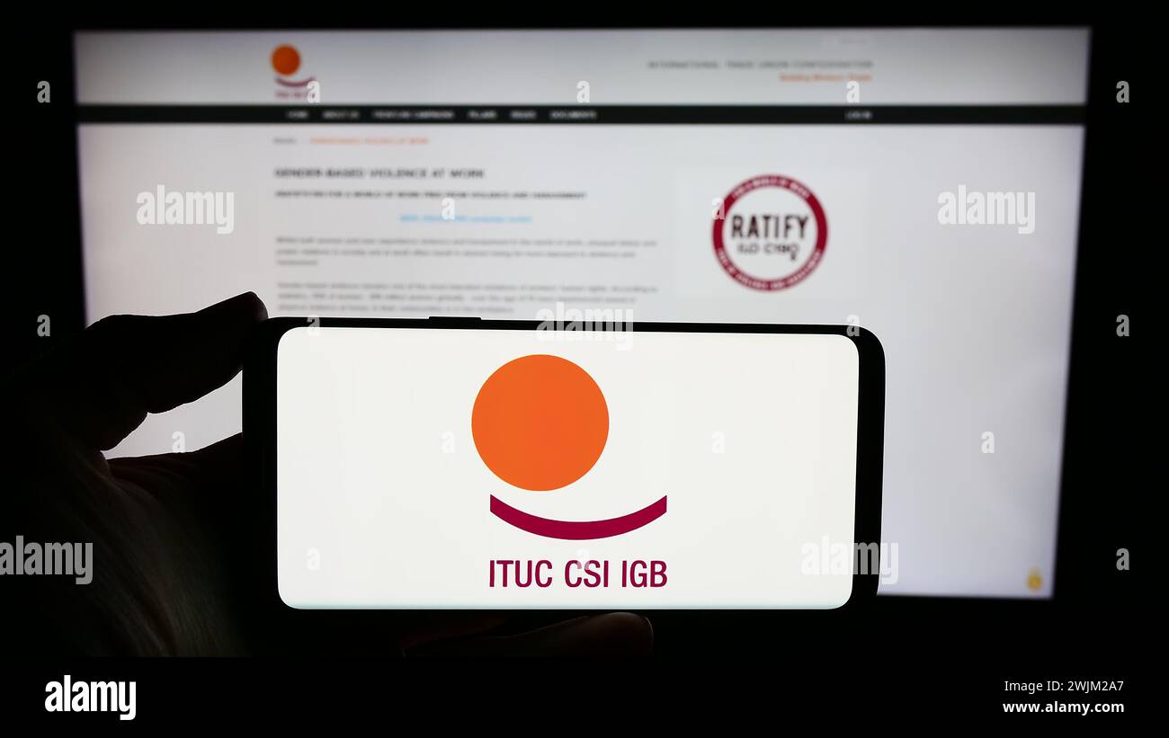 Person holding smartphone with logo of federation International Trade Union Confederation (ITUC) in front of website. Focus on phone display. Stock Photo