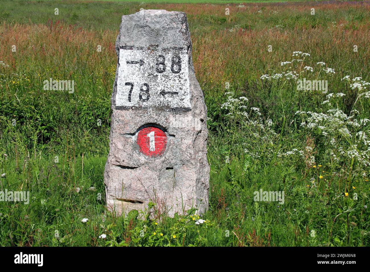 Old milestone made of granite by Highway 110 (Previously number 1) in Kitula, Finland in the summer. Stock Photo