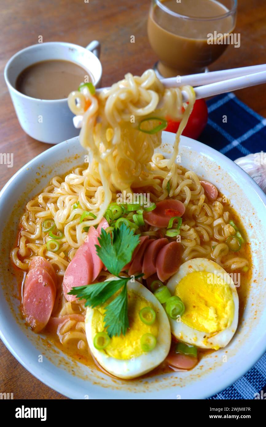 Photo of noodle soup with toppings such as sausages, eggs, and vegetables Stock Photo