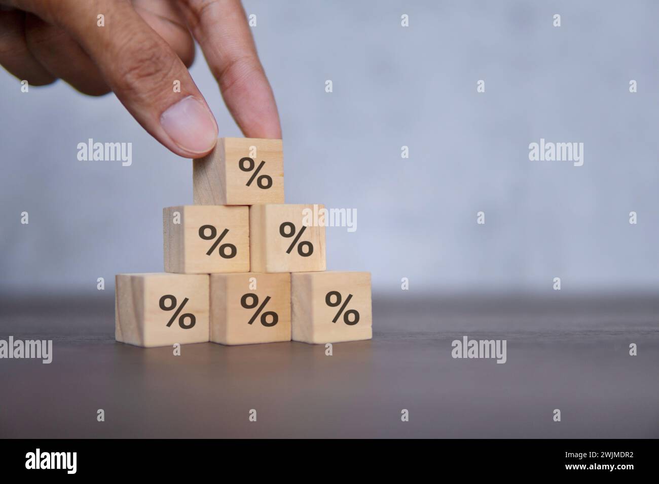 Hand arranging stacking wooden blocks with percentage icon. Debt restructure concept. Stock Photo