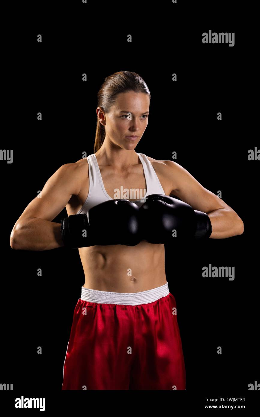 Young Caucasian woman poses confidently in boxing gear, with copy space ...