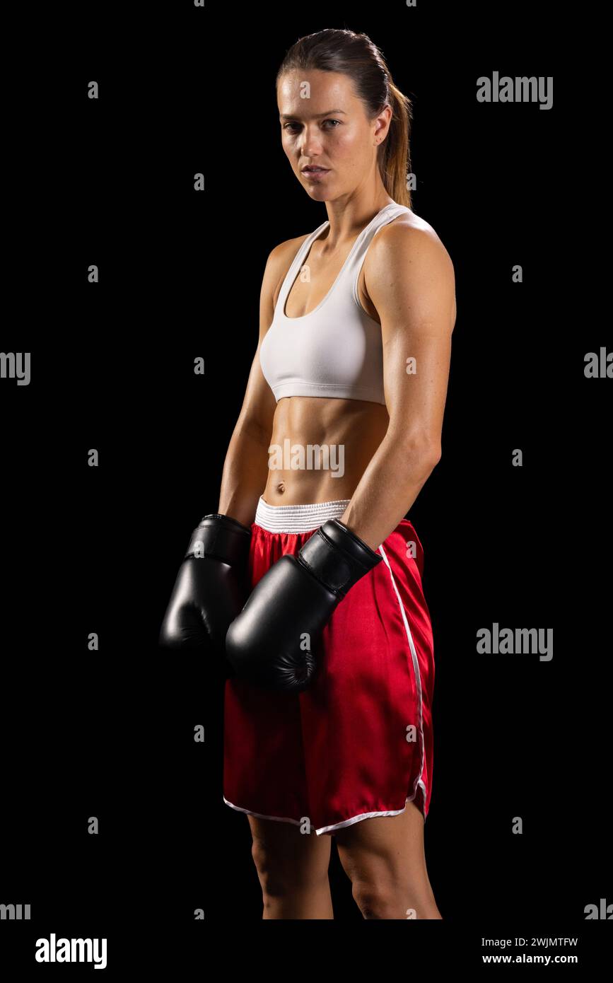 Young Caucasian woman poses confidently in boxing attire, with copy ...
